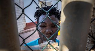 A migrant from Sudan looks through a fence in a refugee centre in Melilla on Saturday in Melilla, a day after the 23cdeaths