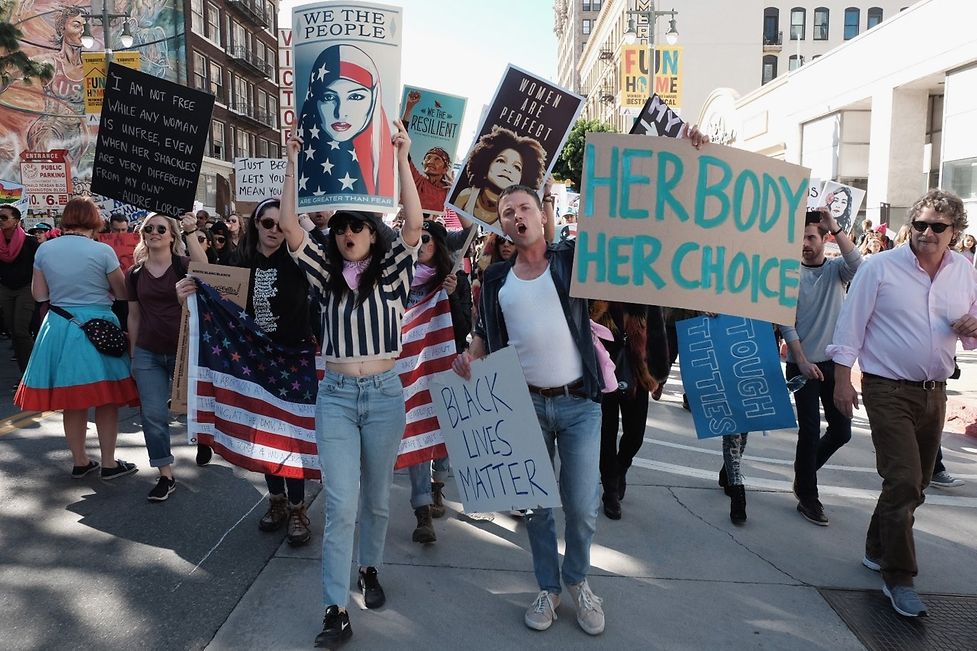 Marchers hold signs during the Women's March on January 21, 2017 in Los Angeles, California. The "Mexico City Policy" has been instituted by every Republican President since 1984.