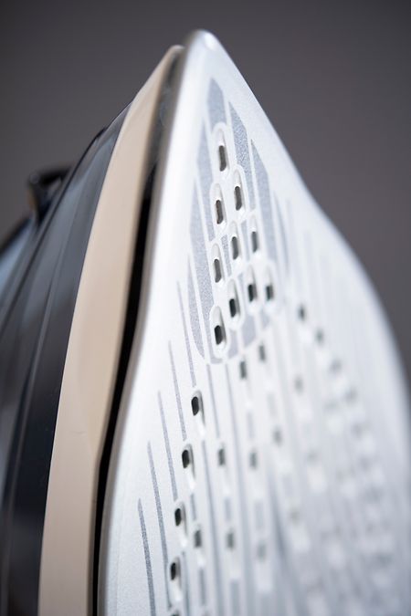 Die Arbeit geht leichter von der Hand, wenn man ein Bügeleisen mit vielen kleinen Löchern am Boden hat. Durch diese gelangt der Dampf gleichmäßig und gut auf den Stoff.