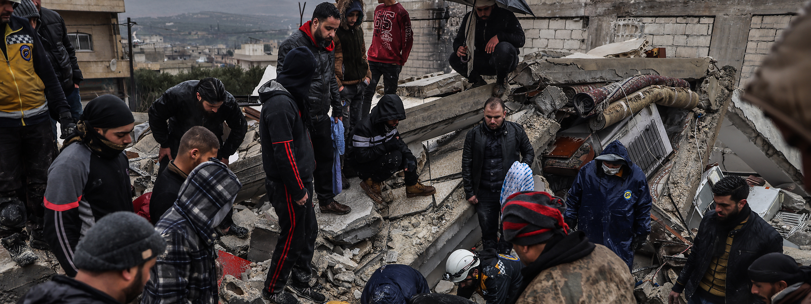 Syrische Zivilisten und Mitglieder der Weißhelme arbeiten an der Rettung von Menschen, die nach dem Erdbeben in Idlib unter einem zerstörten Gebäude eingeschlossen sind. Die bereits zuvor durch den Bürgerkrieg in weiten Teilen zerstörte Stadt ist zu einer einzigen Trümmerwüste geworden.