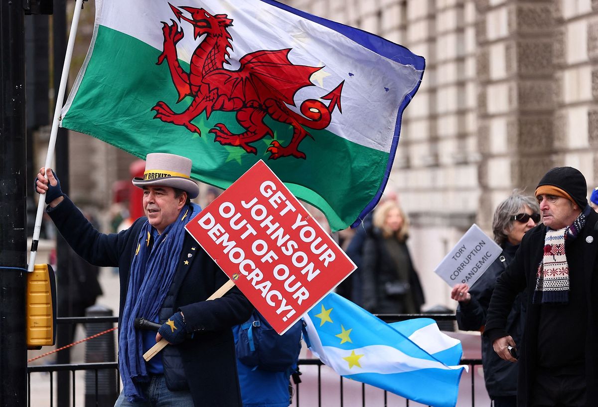 Anti-Brexit activist Steve Bray holds a placard reading "Get your Johnson out of Democracy" as he holds a Welsh flag while demonstrating outside of the House of Commons in London on Wednesday.
