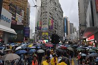 People gather for a rainy protest march in the Causeway Bay shopping district of Hong Kong on October 6, 2019. - A Hong Kong judge on October 6 rejected a challenge to an emergency law criminalising protesters wearing face masks as democracy activists hit the streets again in defiance of the ban despite half the city's subway stations remaining closed. (Photo by Nicolas ASFOURI / AFP)