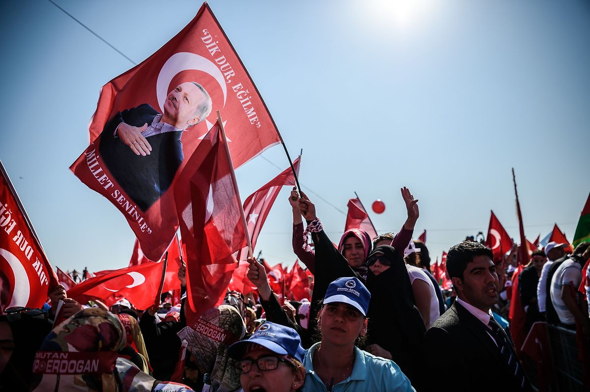 Die Menschen tragen Türkei-Flaggen mit Erdogan-Motiv bei sich. 