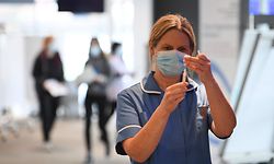 A healthcare professional draws up a dose of AstraZeneca/Oxford Covid-19 vaccine in a syringe at the vaccination centre set up at Chester Racecourse, in Chester, northwest England, on February 15, 2021. - Prime Minister Boris Johnson on February 14 called Britain hitting a target of inoculating 15 million of the most vulnerable people with a first coronavirus jab "a significant milestone", as the country prepared for the next phase of its vaccination programme. (Photo by Oli SCARFF / AFP)