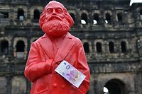 This picture taken on April, 10, 2018 in Trier, southwestern Germany, shows a red figure of German philosopher Karl Marx with a Zero-Euro-bank note realeased on the occasion of Marx's bicentenary.
On May 5, 2018 is the 200th anniversary of Marx's birth. / AFP PHOTO / dpa / Harald Tittel / Germany OUT
