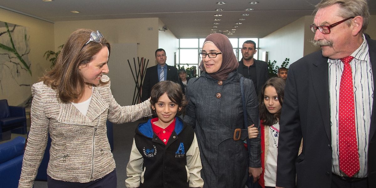 La ministre Corinne Cahen accueillant des familles de réfugiés en 2014 aux côtés du bourgmestre de Weilerbach, Ernest Walerius