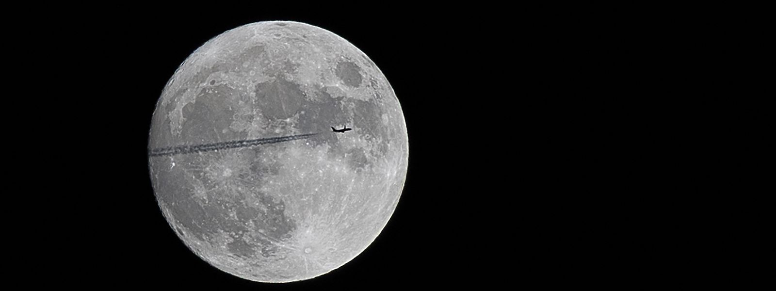 Um avião de passageiros Boeing 737 da Jet2 Airlines que viaja de Londres para Palma de Maiorca voa em frente à lua, fotografado a partir de Toulouse, sul de França.