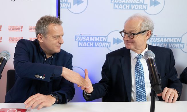 Roman Zitzelsberger (left), district manager of IG Metall Baden-Wuerttemberg, shakes hands with Harald Marquardt, deputy chairman of Südwestmetall