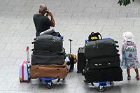 Travellers wait with their suitcases before checking in on July 2, 2021 at the airport of Duesseldorf as summer holidays begin in this western German area. - If the Delta variant becomes dominant in Germany, so-called coronavirus variant countries such as Britain and Portugal -- from which most travel is currently banned -- could be reclassified, German Health minister said on July 1, 2021. (Photo by Ina FASSBENDER / AFP)