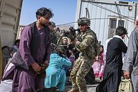 Um soldado americano aponta uma arma a um passageiro afegão no aeroporto de Cabul, a 16 de agosto de 2021. Os soldados tentavam conter as multidões que se aglomeravam no aeroporto da cidade tentando fugir do domínio dos talibãs, que tomaram o poder a 15 de agosto. 