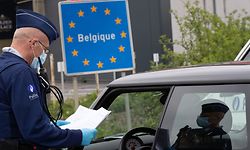 (FILES) In this file photo taken on April 19, 2020 a Belgian Police officer controls the documents of a person in a car at the border between Belgium and France during a police patrol in Quevy, enforcing the social distancing rules, as Belgium is in its fifth week of lockdown to fight the COVID-19 outbreak, caused by the novel coronavirus. - An European coordination for a return to free movement between European countries is delicate, between health imperatives and economic emergency, after the closings of the borders which have damaged a symbol of the European Union. (Photo by BENOIT DOPPAGNE / BELGA / AFP) / Belgium OUT