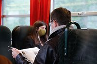 Ein Stück Alltag: Die Zeitungslektüre während der Zugfahrt. Jetzt mit Maske.