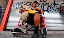 TOPSHOT - A man in a wheelchair poses with a box with donations of basic goods handed to him by employees of the foundation of Alejandrina Guzman, daughter of Mexican drug lord Joaquin "El Chapo" Guzman, amid the new coronavirus pandemic in Guadalajara, Mexico, on April 17, 2020. (Photo by Ulises Ruiz / AFP)