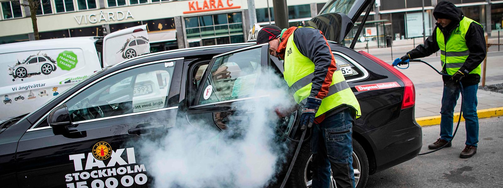 Reinigungskräfte in der schwedischen Hauptstadt Stockholm desinfizieren ein Taxi. Trotz der Verbreitung des Virus, bleiben Restaurants und Geschäfte weiterhin geöffnet.
