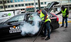 TOPSHOT - Two men clean and desinfects a taxi car in Stockholm, Sweden, on March 24, 2020, to prevent the spread of the coronavirus, Covid-19. - The country's milder tone and measures are in stark contrast to the increasingly alarmist cries from many other countries and international agencies, and have sparked a heated debate in the country about whether Sweden is doing the right thing. (Photo by Jonathan NACKSTRAND / AFP)