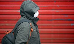 TOPSHOT - A person wearing a face mask as a preventive measure against the COVID-19 disease walks in Vilanova i la Geltru on March 30, 2020. - Spain confirmed another 812 deaths in 24 hours from the coronavirus today, a slight decline on the previous day's toll, bringing the total number of deaths to 7,340. The country, which has the world's second most deadly outbreak after Italy, recorded 838 deaths from the pandemic yesterday, its third straight daily record for coronavirus deaths. (Photo by LLUIS GENE / AFP)