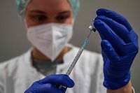 A health worker prepares a syringe with the Comirnaty Covid-19 vaccine by Biontech-Pfizer at a vaccination centre in Berlin's Humborldt Forum museum on January 18, 2022. (Photo by John MACDOUGALL / AFP)