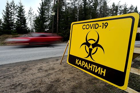 A sign reading "Quarantine COVID-19" is pictured at the entrance to the village of Pervomaiskoye outside Saint Petersburg on May 3, 2020 amid the coronavirus pandemic. - Entry into the settlement has been prohibited since April 30 as the rate of virus infection is 2.5 times higher than in Leningrad region. (Photo by Olga MALTSEVA / AFP)