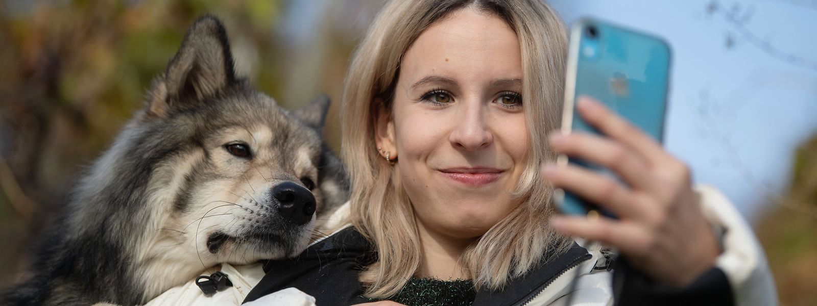 Nicole Lenhardt macht mit ihrem Wolfshund Milo in einem Weinberg ein Selfie. Mit Hilfe ihres Haustiers ist die Stuttgarterin über Internet-Plattformen so erfolgreich geworden, dass sie vor kurzem ihren Job aufgegeben und sich selbstständig gemacht hat.