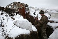 TOPSHOT - An Ukrainian Military Forces serviceman checks his weapon as he stands in a trench on the frontline with the Russia-backed separatists near Zolote village, in the eastern Lugansk region, on January 21, 2022. - Ukraine's Foreign Minister Dmytro Kuleba on January 22, 2022, slammed Germany for its refusal to supply weapons to Kyiv, urging Berlin to stop "undermining unity" and "encouraging Vladimir Putin" amid fears of a Russian invasion. (Photo by Anatolii STEPANOV / AFP)