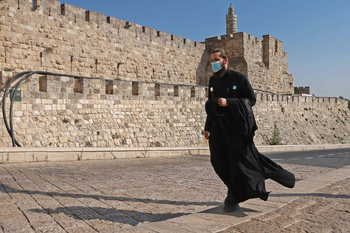 EIn Priester vor den Mauern der alten Stadt in Jerusalem. Diese Lockdownmaßnahmen sollen am Freitagnachmittag um 13 Uhr (MESZ) in Kraft treten, vor Beginn der jüdischen Feiertage, und zunächst für drei Wochen gelten. 