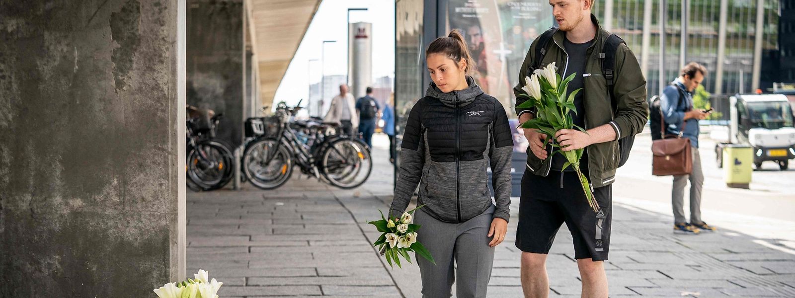 Am Tatort in Kopenhagen legen Menschen Blumen nieder.