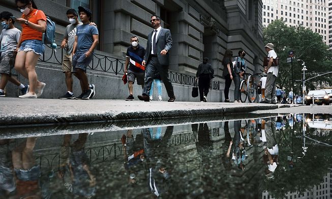 People walk through a part of New York City that increasingly experiences flooding on Monday as the UN's Intergovernmental Panel on Climate Change devastating effects from climate change.