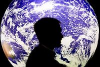 ARCHIV - 11.11.2021, Großbritannien, Glasgow: Ein Mann sitzt bei der UN-Klimakonferenz COP26 vor einem leuchtenden Globus. (zu dpa "Klimaschutz trotz Krieg: Was bringt die Weltklimakonferenz COP27?") Foto: Christoph Soeder/dpa +++ dpa-Bildfunk +++