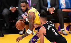 (FILES) In this file photo LeBron James of the Los Angeles Lakers looks to pass under pressure from CJ McCollum of the Portland Trailblazers on January 31, 2020 during their NBA game in Los Angeles. - NBA superstar LeBron James was among the US athletes taking to social media in outrage over the death of a black man in Minnesota after a white policeman kneeled on his neck for several minutes. Four Minneapolis police officers were fired May 26, 2020 as a video showing one of them kneeling on the neck of George Floyd, a handcuffed black man who later died, sparked protests. (Photo by Frederic J. BROWN / AFP)