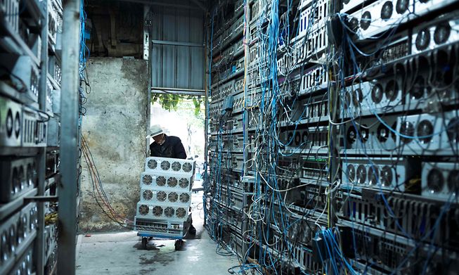 This file photo taken on April 6, 2021 shows a local resident working part time at a cryptocurrency farm in Dujiangyan in China's southwestern Sichuan province