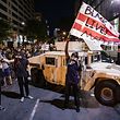 WASHINGTON, DC - JUNE 02: A protestor waves a DC flag with Black Lives Matter spray painted on it next to a DC National Guard Humvee as protestors march through the streets during a demonstration over the death of George Floyd, who died in police custody, on June 2, 2020 in Washington, DC. Protests erupted around the country following the release of a video showing Derek Chauvin, a now former Minneapolis Police officer, kneeling on the neck of Floyd despite Floyd saying I cant breath.   Samuel Corum/Getty Images/AFP
== FOR NEWSPAPERS, INTERNET, TELCOS & TELEVISION USE ONLY ==