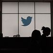 (FILES) In this file photograph taken on August 14, 2019, employees walk past an illuminated Twitter logo as they leave the company's headquarters in San Francisco. - Twitter said May 12, 2020 it is unlikely to open its offices before September, and that many of its employees will be permitted to work from home permanently even after the end of the coronavirus lockdowns. The San Francisco-based company said it was among the first to move to telework in March as a result of the health crisis and that it will continue that policy indefinitely as part of a move towards a "distributed workforce." (Photo by Glenn CHAPMAN / AFP)