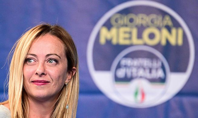 Leader of Italian far-right party Fratelli d'Italia (Brothers of Italy) Giorgia Meloni stands by the party's logo during a rally in Ancona last month