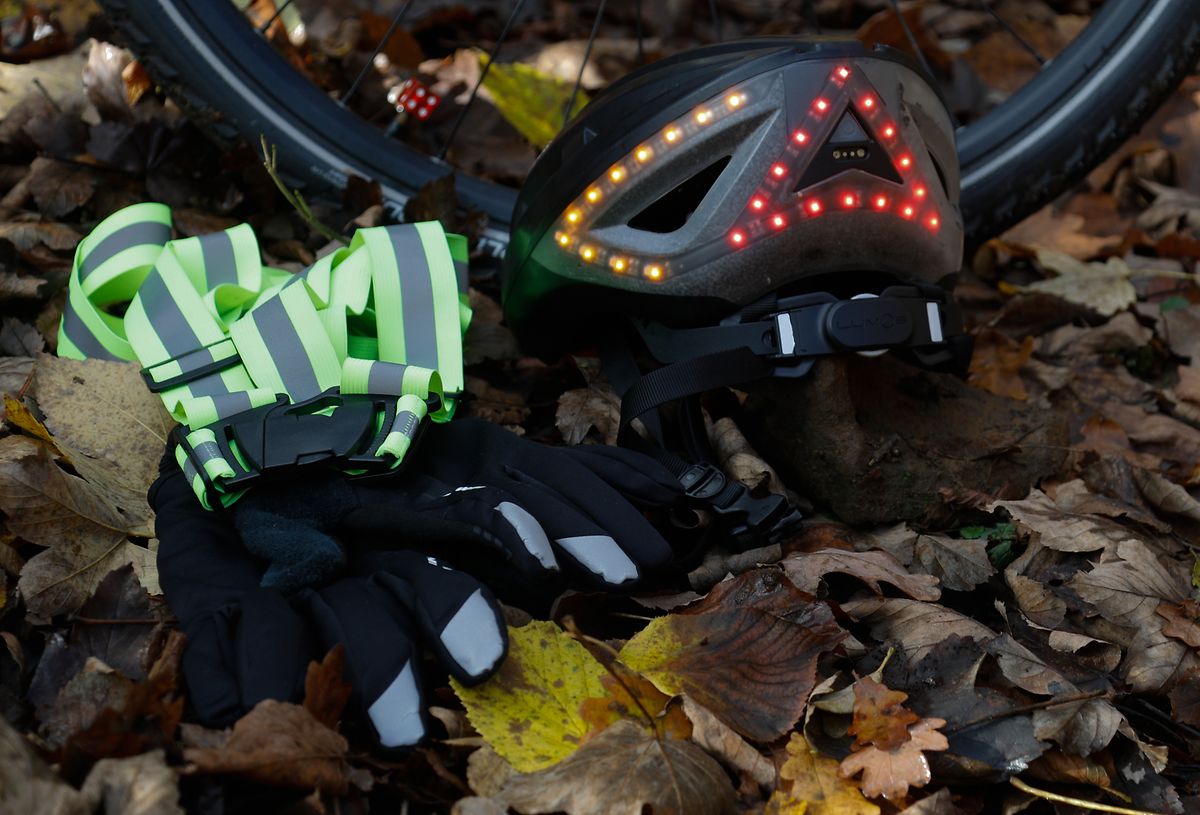 Wer sich nicht auf die Aufmerksamkeit der Autofahrer verlassen will: Ein Fahrradhelm mit Leuchtdioden, Reflektorbänder und rückstrahlende Applikationen etwa auf den Handschuhen verhelfen zu mehr Sichtbarkeit. 