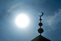 ARCHIV - 19.09.2014, Hessen, Frankfurt/Main: Der Halbmond auf dem Minarett der Abubakr Moschee in Frankfurt (Hessen) hebt sich als Schattenriss vor der Sonne ab. (zu dpa «Religion in Zeiten von Corona: "Das wird ein besonderer Ramadan"») Foto: Boris Roessler/dpa +++ dpa-Bildfunk +++
