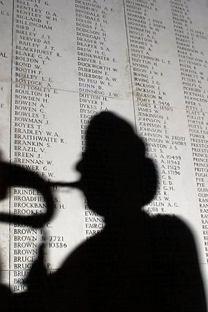 YPRES, BELGIUM - NOVEMBER 7:  A bugler is silhouetted against part of a list 54,896 World War I soldiers who died between 1914 and August 15, 1917 and who have no known grave November 7, 2002 in Yrpes, Belgium. The British memorial honors soldiers who perished in the Flanders region of Belgium during the Great War. More than 8.5 million from both Allied and Central Powers died by the time the conflict ended on 11th hour of the 11th day of November, the 11th month in 1918. Each evening, a group of buglers from the local voluntary fire brigade sound the Last Post, the traditional salute to fallen warriors. The tribute draws an estimated 250,000 spectators annually.  (Photo by Paul O'Driscoll/Getty Images) 