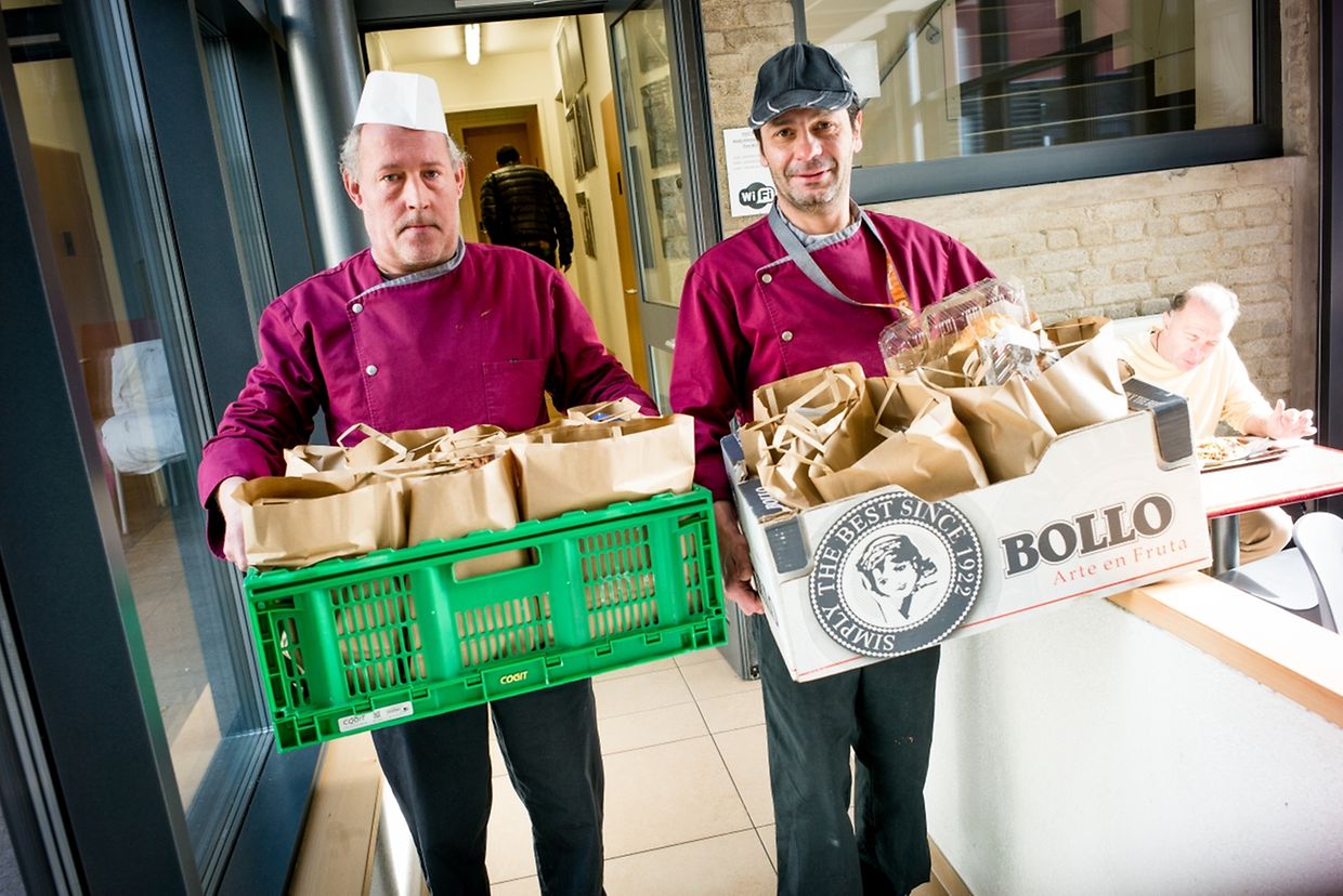 Deux collaborateurs de la Stëmm distribuent des paniers repas