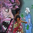 TOPSHOT - Un piéton passe devant une fresque murale représentant un personnel médical de première ligne arrêtant le coronavirus Covid-19, à Navi Mumbai le 7 juin 2021. (Photo par Indranil MUKHERJEE / AFP)