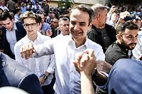 Greece's opposition party New Democracy leader Kyriakos Mitsotakis (C) greets supporters as he leaves a polling station after casting his vote during general elections in Athens on July 7, 2019. - Greek voters are casting their ballots in the country's first national election of the post-bailout era. (Photo by ARIS MESSINIS / AFP)