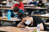 Students wearing protective face masks take part in an examination inside The Flanders Expo "Big Room" in Ghent on May 25, 2020. - Belgium is in its eleventh week of confinement in the ongoing coronavirus crisis and the second week of the second phase of deconfinement. The National Security Council has given the Go to the deconfinement in stages as developed by the Group of Experts for the Exit Strategy. (Photo by NICOLAS MAETERLINCK / BELGA / AFP) / Belgium OUT