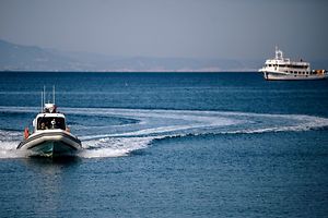 Un bâteau des gardes-côtes escorte un petit ferry transportant des migrants arrivés illégalement en Grèce. Ils sont redirigés vers la Turquie.