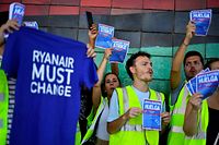 Ryanair employees hold flyers reading "Support our strike" and t-shirts reading "Ryanair must change" as they protest at the Terminal 2 of El Prat airport in Barcelona on June 24, 2022. - Trade unions representing Ryanair cabin crew in Belgium, France, Italy, Portugal and Spain have called for strikes this coming weekend, while easyJet's operations in Spain face a nine-day strike next month. (Photo by Pau BARRENA / AFP)