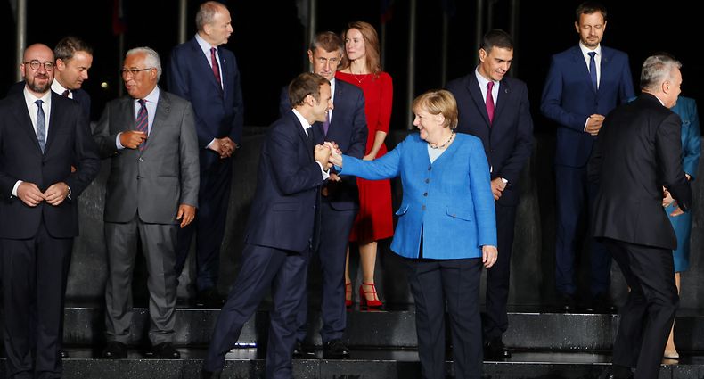 TOPSHOT - France's President Emmanuel Macron (CL), Germany's Chancellor Angela Merkel (CR), Eu members states and Western Balkans partners' representants pose as they arrive at the EU-Western Balkans summit at Brdo Castle in Kranj on October 5, 2021. - EU leaders will have a hard discussion on Europe's place in the world at a summit, as they seek unity on how to deal with superpowers China and the United States. The 27 heads of state and government will meet at Brdo Castle in Slovenia, the country that currently holds the EU's rotating presidency. (Photo by Ludovic MARIN / AFP)