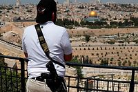 A Jewish man holding a gun stands on the Mount of Olives looking out over Jerusalem's Old City and the Dome of the Rock (C) as he observes two minutes of silence to mark Remembrance Day which commemorates Israel's fallen soldiers on April 18, 2018.
Israel mark the Remembrance to commemorate over 23,646 fallen soldiers since 1860, just before the celebrations of the 70th anniversary of its creation according to the Jewish calendar. / AFP PHOTO / AHMAD GHARABLI
