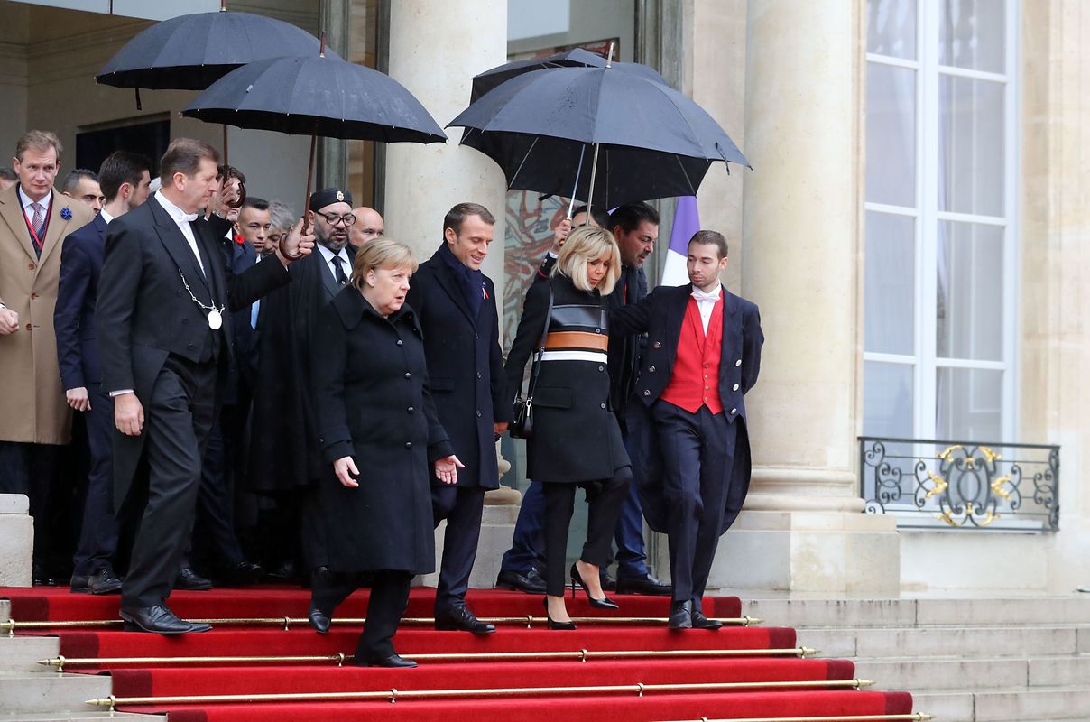 French President Emmanuel Macron (C), his wife Brigitte Macron (R), German Chancellor Angela Merkel (L) and other heads of state and government leave the Elysee Palace in Paris on November 11, 2018 for the Arc de Triomphe prior to the start of commemorations marking the 100th anniversary of the 11 November 1918 armistice, ending World War I. (Photo by JACQUES DEMARTHON / AFP)