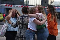 TOPSHOT - People embrace as police evacuate of the Fields shopping center in Copenhagen, Denmark, on July 3, 2022 after Danish media reported a shooting. - Gunfire in a Copenhagen mall left "several dead," and several wounded Danish police said. (Photo by Olafur Steinar Gestsson / Ritzau Scanpix / AFP) / Denmark OUT