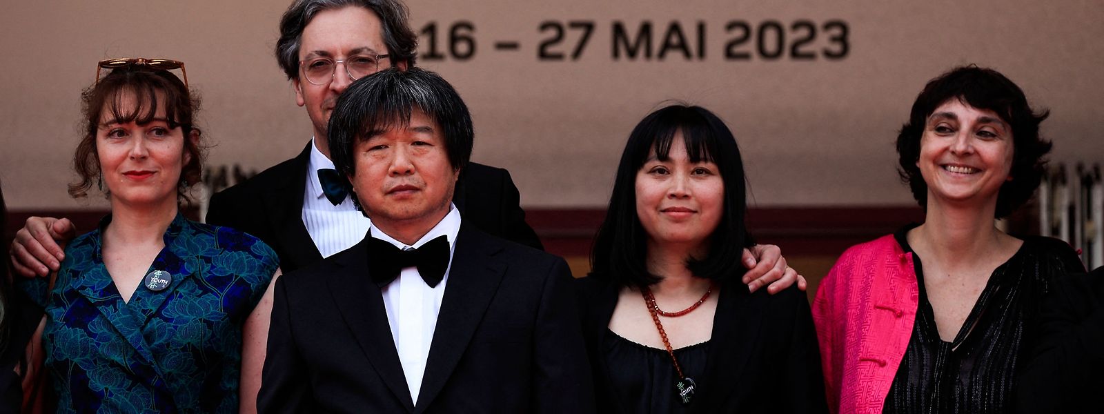 Der chinesische Regisseur Wang Bing (3.v.r.) bei der Weltpremiere seines Dokumentarfilms "Youth - Spring" bei der Premiere am 18. Mai 2023 in Cannes. 