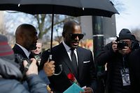 (FILES) In this file photo taken on March 22, 2019 US music artist R. Kelly (C) holds a card and a rose he received from fans as he leaves the George N. Leighton Criminal Court Building after a hearing for his sex abuse case in Chicago, Illinois. - Chicago prosecutors on May 30, 2019 filed 11 felony sex crime charges against R&B superstar R. Kelly, in what his lawyer said was a refiling of counts from an existing case. Kelly is already facing 10 felony charges, filed in February, for the alleged abuse of four women. (Photo by Joshua Lott / AFP)
