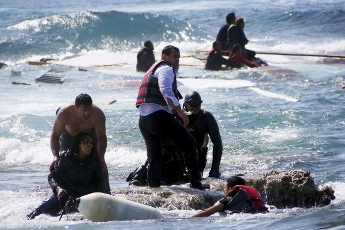 Mitglieder der griechischen Rettungswache helfen Migranten an Land.