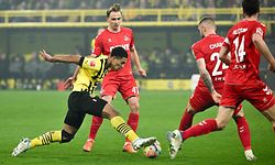 Dortmund's English midfielder Jude Bellingham (L) and Cologne's Luxembourgian midfielder Mathias Olesen vie for the ball during the German first division Bundesliga football match between Borussia Dortmund and FC Cologne in Dortmund on March 18, 2023. (Photo by INA FASSBENDER / AFP) / DFL REGULATIONS PROHIBIT ANY USE OF PHOTOGRAPHS AS IMAGE SEQUENCES AND/OR QUASI-VIDEO